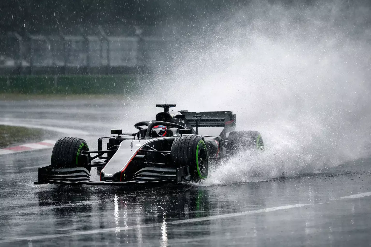 Formel-1-Auto mit Intermediate-Reifen fährt durch Regen auf nasser Strecke